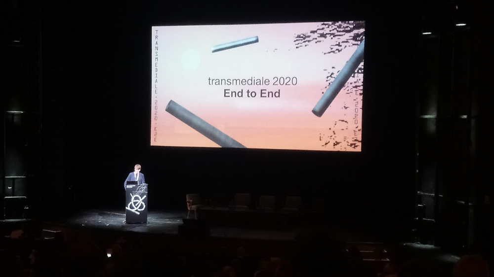 A big screen in the darkness saying 'transmediale 2020 End to End'.